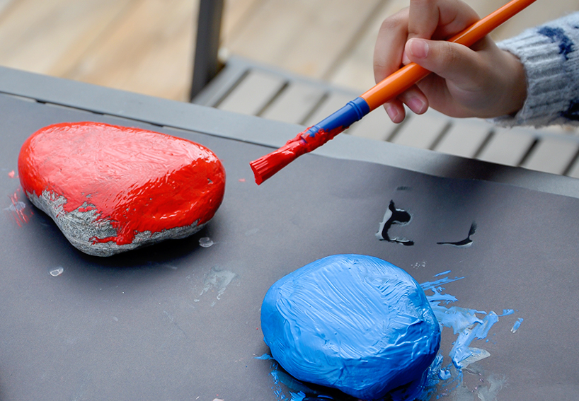 Jar of red paint; 1 rock painted red, 1 rock painted blue